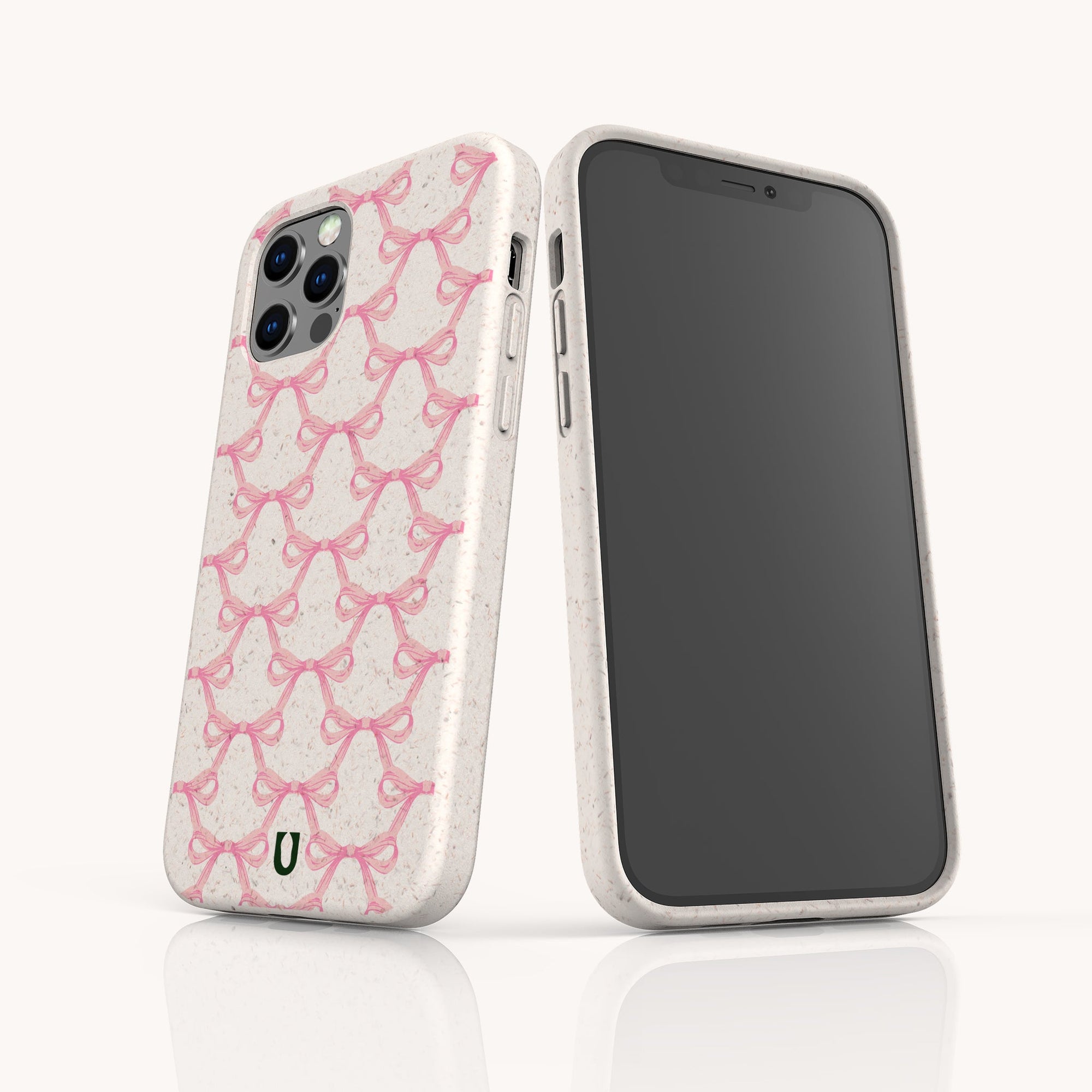 Two smartphones in off-white Pink Bow Ribbons Eco-Friendly Biodegradable Phone Cases, featuring a repeating pink ribbon pattern for breast cancer awareness—one displays the design, the other its black screen.