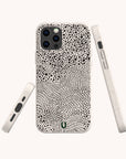 Three views of a smartphone with the Mini Strokes Eco-Friendly Biodegradable Phone Case, showcasing a white base adorned with black, irregular dots and lines forming an abstract pattern. This plant-based phone case covers the back and sides of the phone and features precise cutouts for buttons and ports.