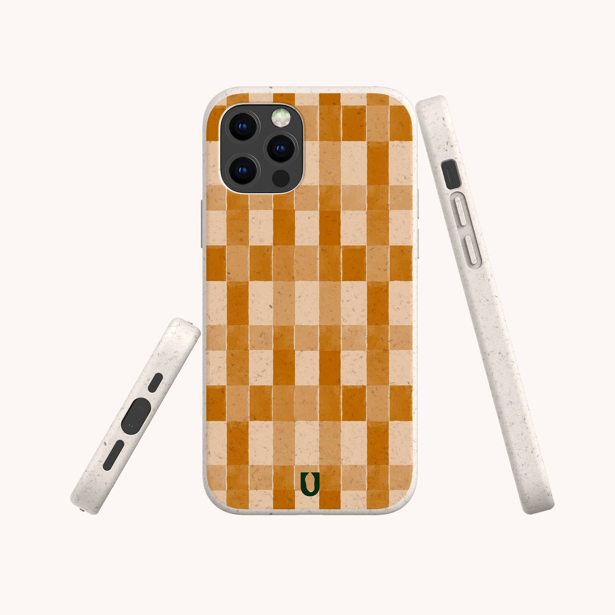 Three views of the Brown Watercolour Checker Eco-Friendly Phone Case are shown against a plain background. This white phone case features an orange and beige checkerboard watercolour pattern on the back, accented with a small green horseshoe icon at the bottom of the design.