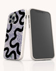 Two smartphones in white cases featuring black wavy and blue dotted patterns are displayed, one revealing the back design and the other showing a blank screen and side buttons, both standing upright on a white surface. Each phone is protected by the Speckled Swirl Eco-Friendly Biodegradable Phone Case, combining stylish design with sustainability.