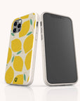 Two smartphones in white cases featuring the Lemons Eco-Friendly Phone Case design—a cheerful yellow lemon pattern with green leaves. One phone highlights the Lemons Eco-Friendly Phone Case, while the other displays its blank front screen. Both phones are standing upright on a white surface.