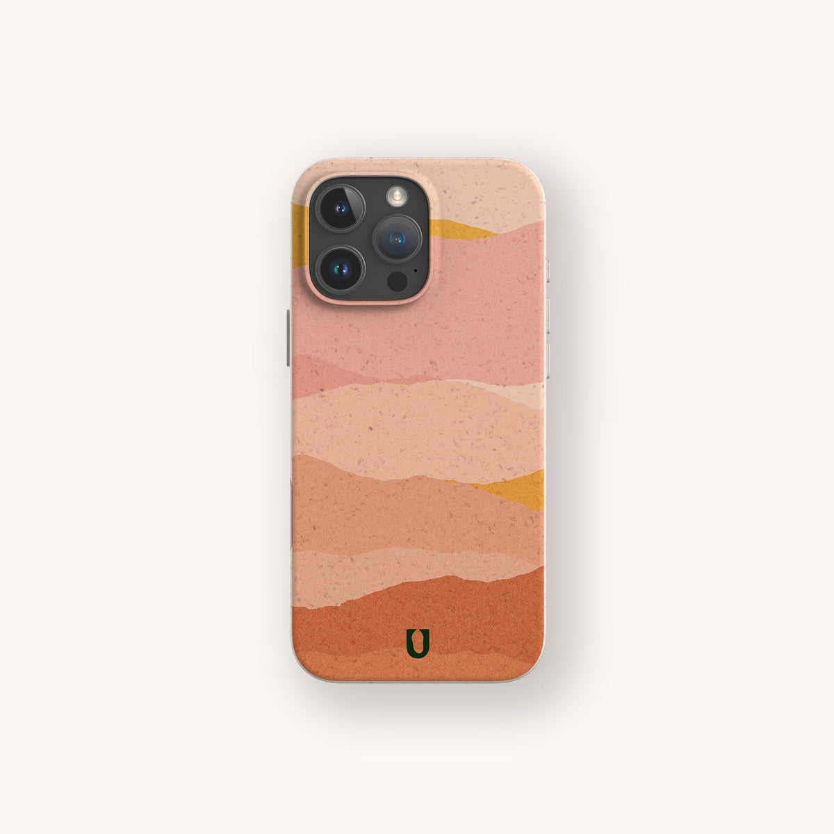 Mountains Eco-Friendly Phone Case: Add a touch of style and sustainability to your smartphone with this eco-friendly phone case, compatible with iPhone and Samsung. Featuring wavy, layered patterns in pink, tan, and orange hues on a beige-pink gradient background, the design is accented by a small green horseshoe-shaped logo at the bottom. The Mountains Eco-Friendly Phone Case combines environmental consciousness with bold aesthetics for your phone’s camera.