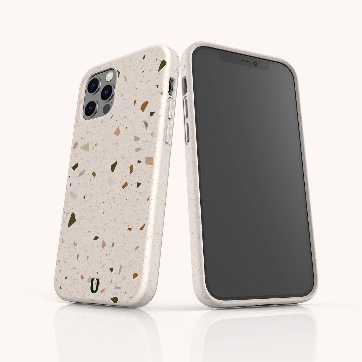 Two smartphones are shown with Brown Terrazzo Eco-Friendly Phone Cases—one facing front, one back. The compostable cases feature a terrazzo-style design with multicolored speckles, precise cutouts for the camera and buttons, and a small green horseshoe logo at the bottom.