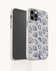 A smartphone with the Sea Shells Eco-Friendly Phone Case in beige, featuring blue seashell and sea life illustrations, stands upright to display both its front screen and the decorative back.