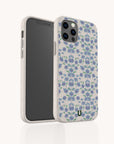 A smartphone in the Blue Ditsy Flowers Eco-Friendly Biodegradable Phone Case, featuring a white speckled finish with a blue and green floral pattern, shown from the front and back against a plain white background.