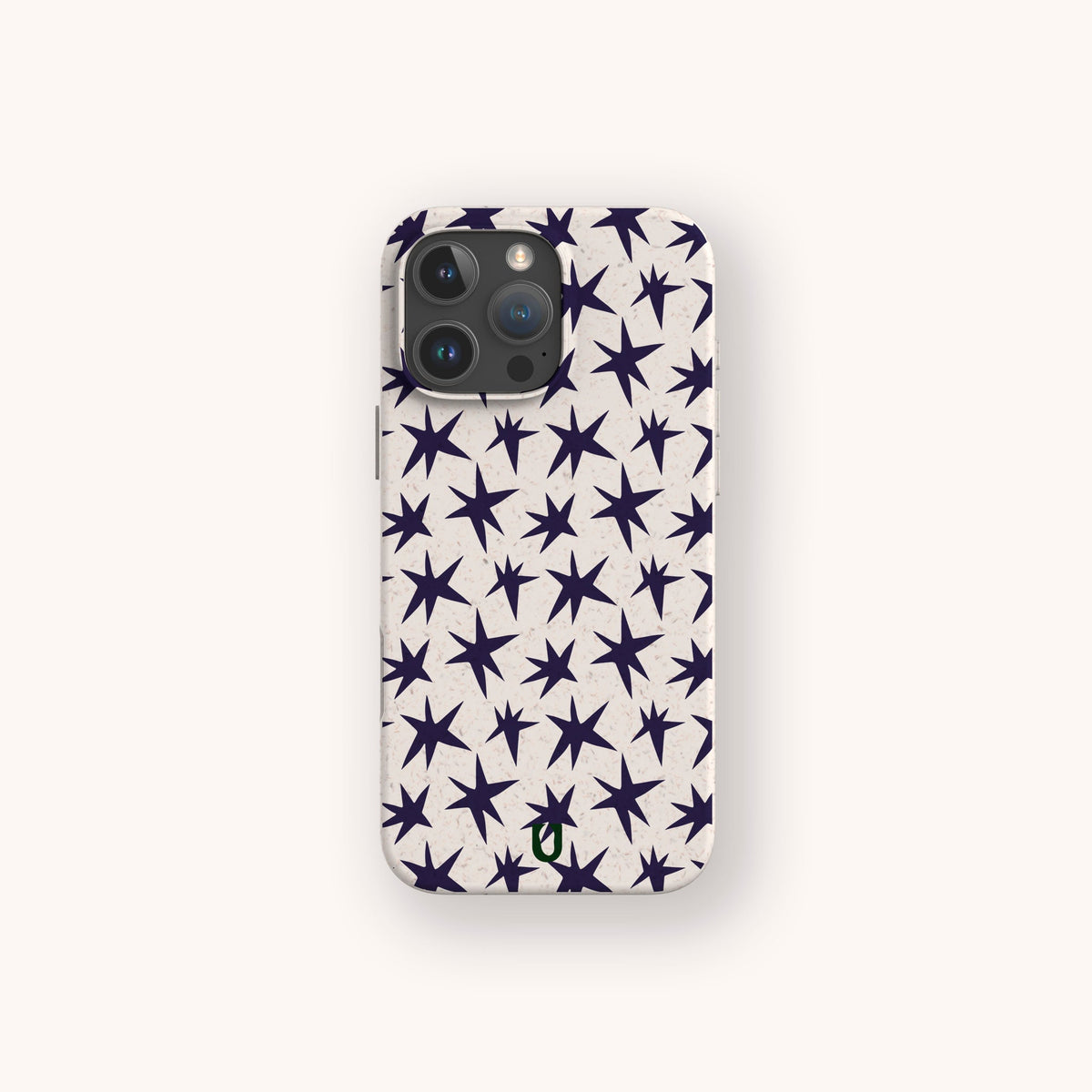 The Wonky Stars Biodegradable Phone Case is shown from the back, featuring a plant-based design with dark blue star patterns on a light beige background, centered on a plain off-white surface.