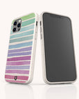 Two smartphones with white speckled, eco-friendly Winter Rainbow phone cases—one showing a pastel rainbow stripe design on the back and the other revealing its front black screen—stand upright against a white background.