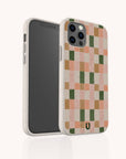 The Pink and Green Watercolour Eco-Friendly Phone Case, featuring a beige base with a pink, green, and peach checkerboard pattern, is displayed standing upright with the back and side partially visible.