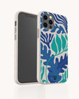 A smartphone in the Sea Bed Eco-Friendly Phone Case, featuring blue and green abstract leaf patterns, stands upright and slightly angled to display both its screen and the distinctive decorative back.