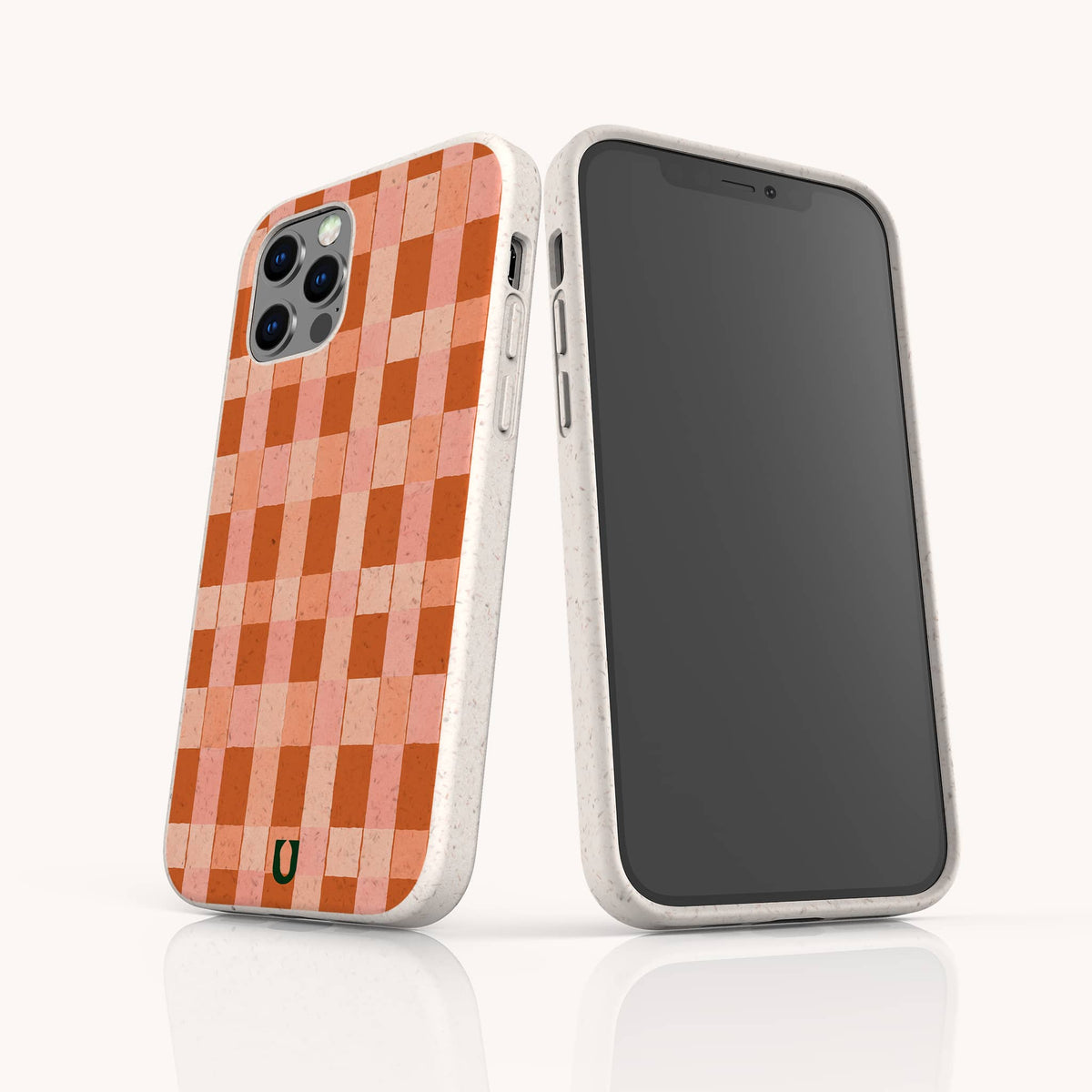 Two smartphones in white speckled eco-friendly phone cases—one showcasing the Terracotta Watercolour Checker pattern, the other displaying a blank black screen—stand upright on a white background. These compostable phone cases are compatible with iPhone and Samsung devices, blending stylish protection with sustainable design.
