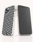 Two smartphones in white cases are displayed on a clean white surface; one showcases the Black Flower Checker Eco-Friendly Phone Case with its bold black-and-white floral checker design, while the other reveals the phone’s blank screen.