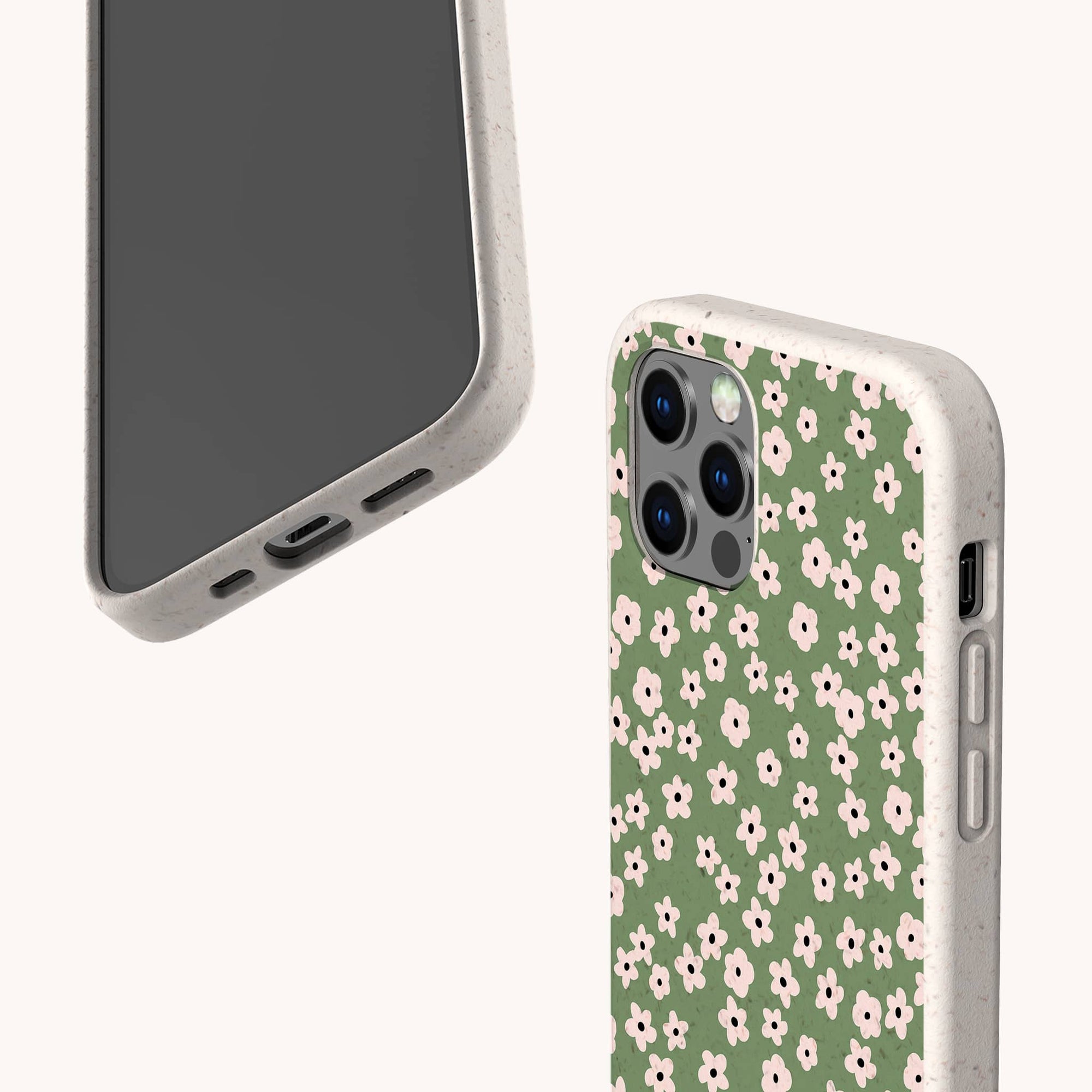 Two smartphones in beige cases: one plain, the other features the eco-friendly Vintage Green Flowers Phone Case with a green background and delicate white and pink flowers. Both are set against a light background.