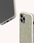 Two smartphones in beige cases are shown. The back case displays the unique green wavy pattern of the Green Distorted Lines Eco-Friendly Phone Case, while the front showcases the phone screen. Both cases feature a textured, eco-friendly design, making them a perfect sustainable phone case option compatible with iPhone and Samsung models.