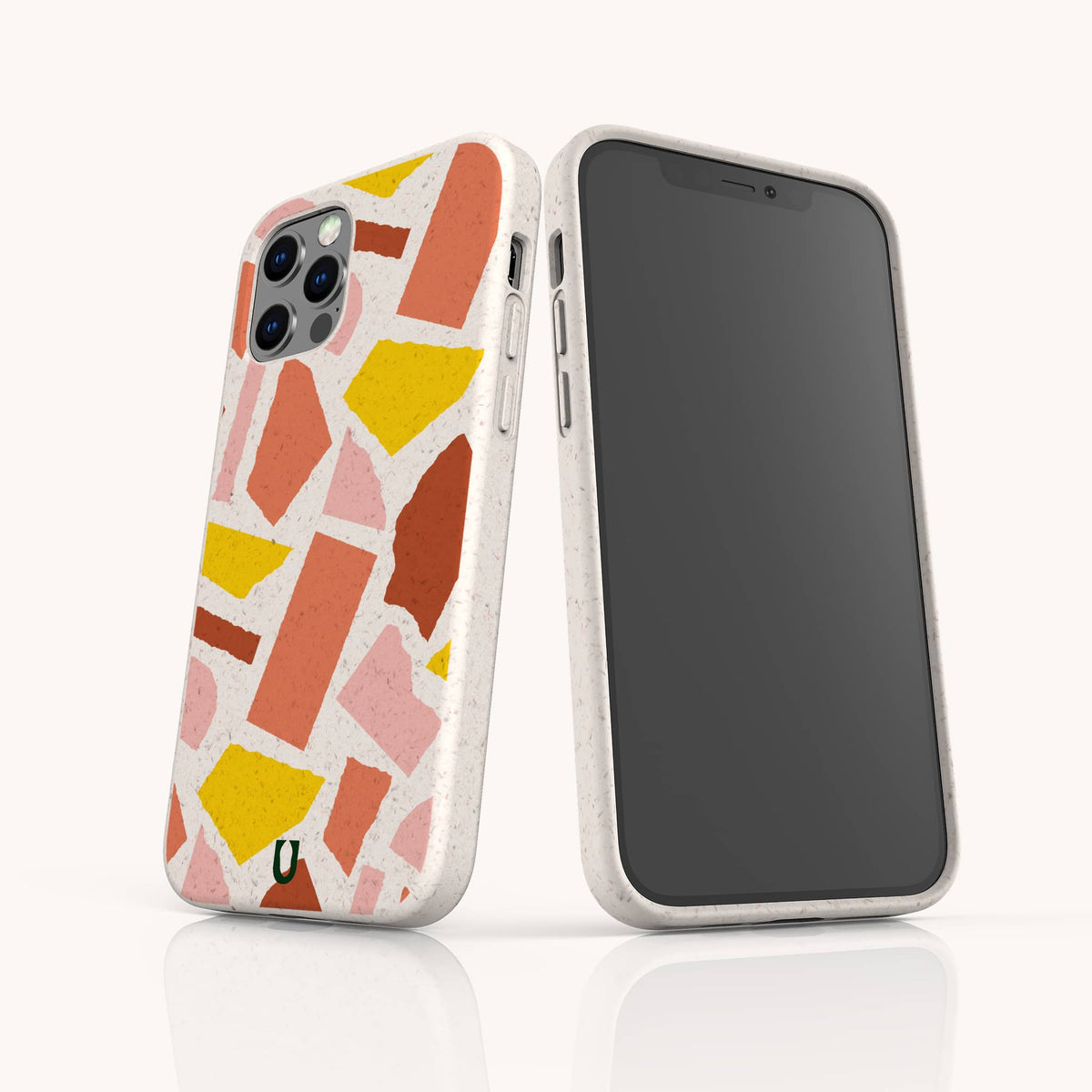Two smartphones with white cases display the Paper Scraps Eco-Friendly Biodegradable Phone Case, featuring a vibrant, abstract terrazzo pattern in shades of pink, orange, yellow, and red. One phone reveals the back while the other shows the front screen, both standing upright on a white surface and highlighting these stylish cases perfect for a colorful and sustainable lifestyle.