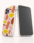 Two smartphones with white cases display the Paper Scraps Eco-Friendly Biodegradable Phone Case, featuring a vibrant, abstract terrazzo pattern in shades of pink, orange, yellow, and red. One phone reveals the back while the other shows the front screen, both standing upright on a white surface and highlighting these stylish cases perfect for a colorful and sustainable lifestyle.
