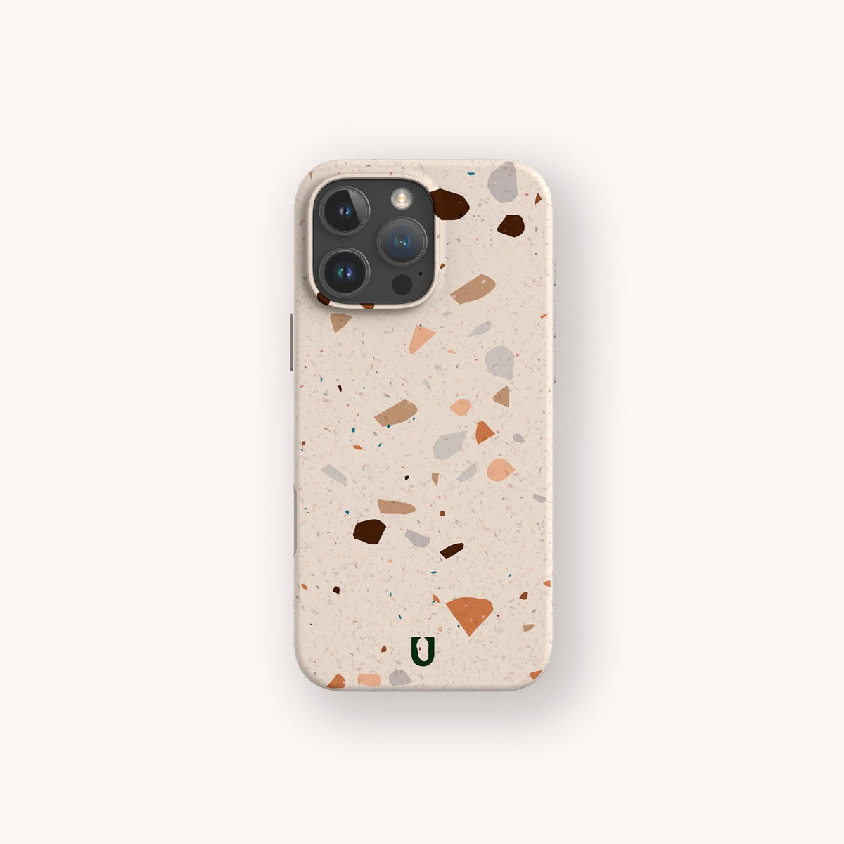 Introducing the Terrazzo Print Eco-Friendly Phone Case: an earth-conscious smartphone accessory featuring a terrazzo pattern of scattered brown, tan, and pink specks. This stylish case is adorned with a small green U logo near the bottom center and offers sustainable protection for your phone.