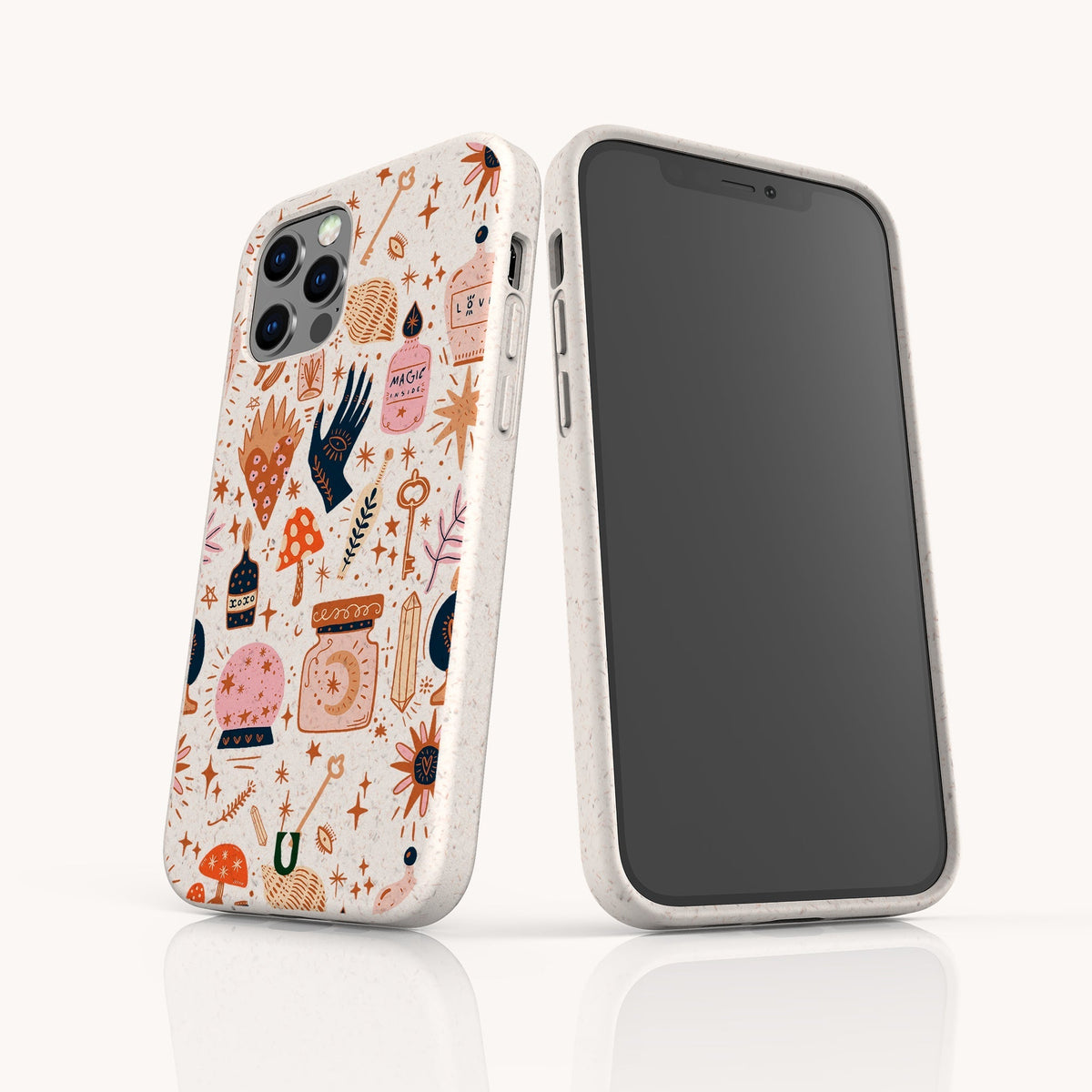 Two smartphones in white speckled cases; one features a blank screen, while the other displays a vibrant, whimsical pattern with mushrooms, hearts, stars, and magical illustrations. Each device is encased in the Love Spell Eco-Friendly Phone Case—offering playful style and sustainable protection for those who value zero-waste living.