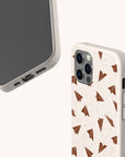Two Paper Planes Eco-Friendly Biodegradable Phone Cases in beige are displayed, one showcasing the front and the other the back. The back of each plant-based phone case features a repeating brown paper airplane pattern, and both cases have a subtly speckled texture.