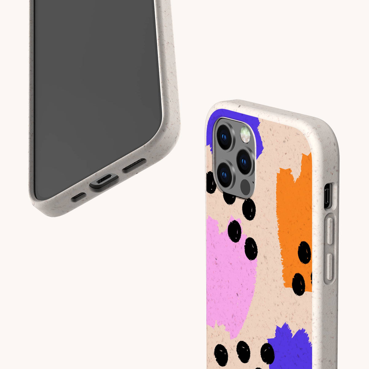 Two smartphones in beige cases; one displays the screen while the other shows the back, featuring the Memphis Eco-Friendly Biodegradable Phone Case with a colorful abstract design of pink, orange, and blue patches accented by scattered black dots on a textured background.