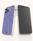 Two smartphones in white cases are displayed upright on a white surface; one reveals the blank front screen, while the other showcases the eco-friendly Cobalt Distort Lines Eco-Friendly Phone Case, featuring a striking wavy blue and white optical illusion pattern on the back. This sustainable case is available for both iPhone and Samsung Galaxy models.