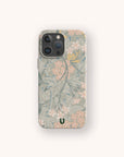 A smartphone with the Jasmine Eco-Friendly Phone Case, featuring a soft, pastel floral pattern in shades of green, beige, and pink with small flowers and leaves. This sustainable phone case also includes a small green U logo near the bottom.