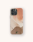 IPhone with the Pink and Brown Watercolour Eco-Friendly Phone Case, featuring abstract watercolor shapes in peach, tan, and beige tones accented by thin black lines and a small green “U” logo at the bottom center. The background is off-white.