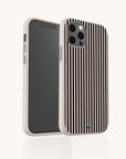 A smartphone with a black screen is displayed in the Thin Black Stripes Eco-Friendly Phone Case, featuring vertical black lines and a small green logo at the bottom. The minimalist phone case stands upright against a white background with its beige and black striped design.