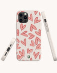 Four Pink Hearts Eco-Friendly Biodegradable Phone Cases are displayed from different angles on a cream-colored background, each adorned with hand-drawn red hearts. The camera cutout is visible in the top left corner. This playful and modern design makes the Pink Hearts Eco-Friendly Biodegradable Phone Case a perfect choice for anyone seeking stylish yet sustainable accessories.