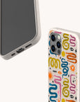 Two smartphones in white speckled “Year Of The Snake” Eco-Friendly Biodegradable Phone Cases; one displays a vibrant, abstract pattern with squiggles, loops, and stars, while the other is plain. These sustainable cases are beautifully designed, and the phones are positioned to showcase both front and back views.