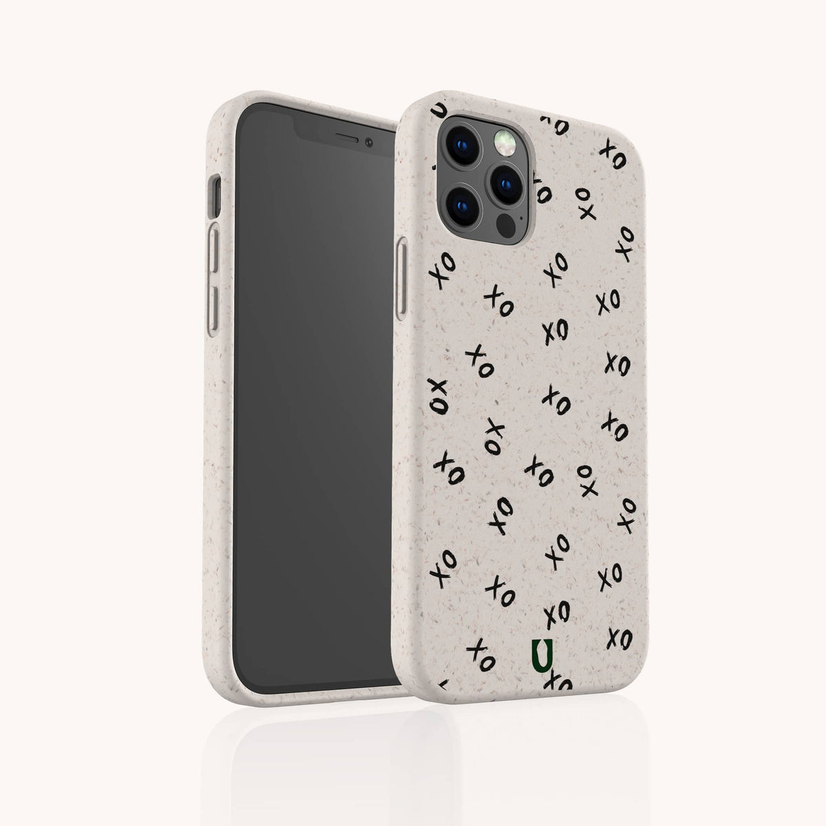 A Xo Xo Eco-Friendly Biodegradable Phone Case, made from plant-based materials, is shown on a smartphone. The white speckled case features a repeating black “xo” text pattern and a small green U logo at the bottom. The background is plain and light-colored.