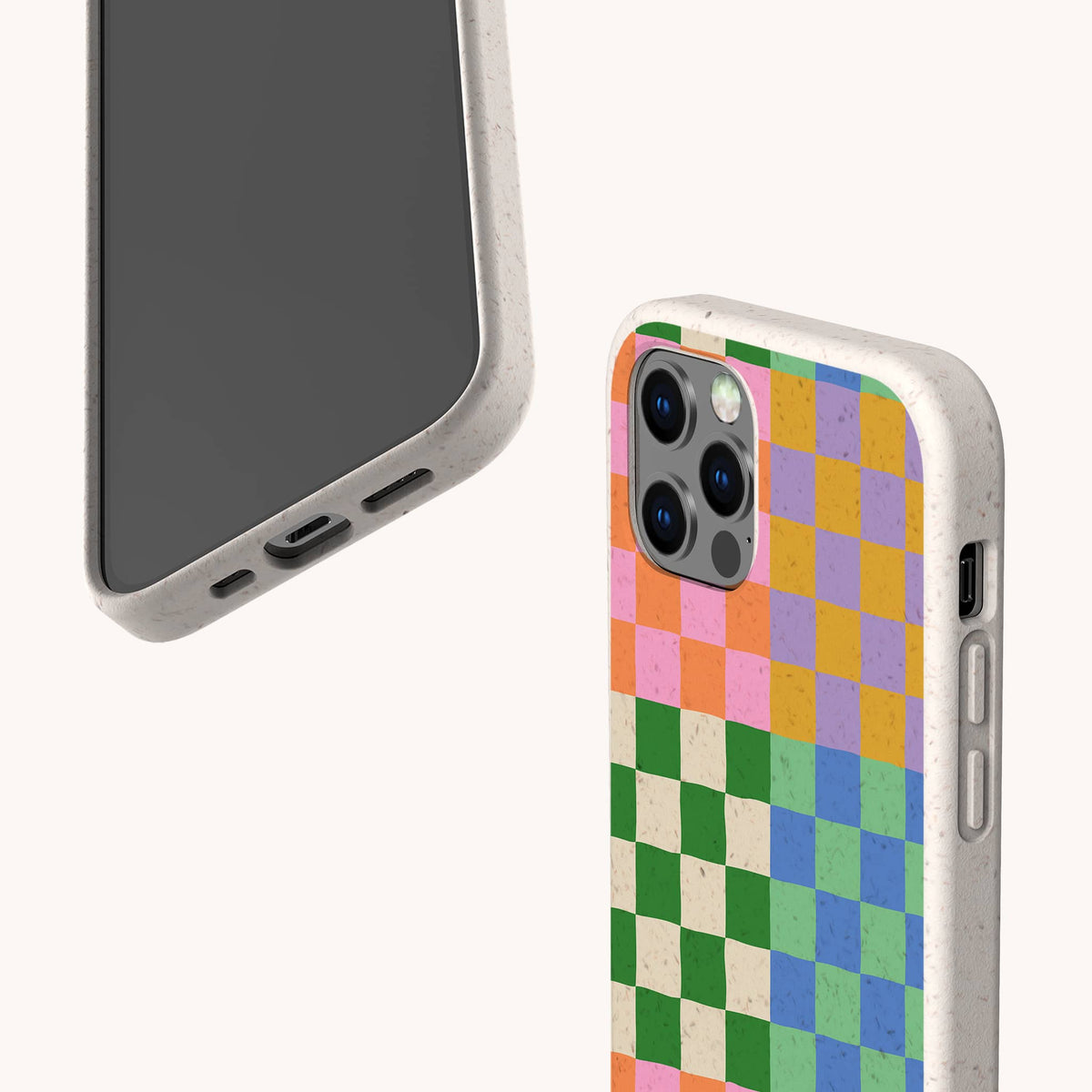 Two smartphones in speckled beige Colour Checker Eco-Friendly Phone Cases—one showing the screen, the other displaying the back with a vibrant pattern of pink, green, yellow, blue, and orange squares. The Colour Checker Eco-Friendly Phone Case is available for both iPhone and Samsung Galaxy models.