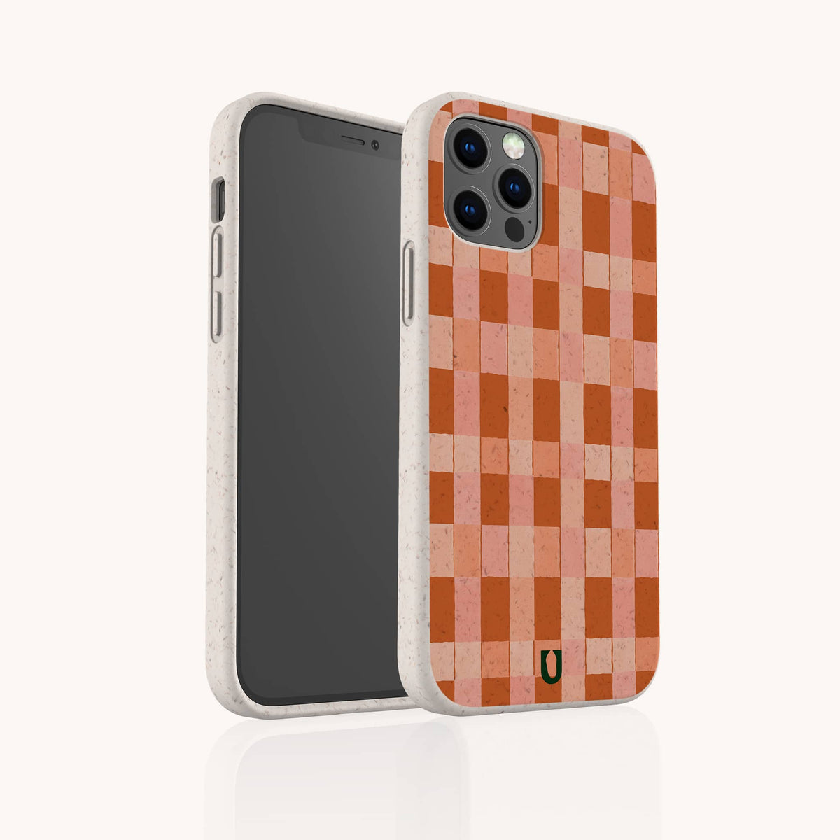 The Terracotta Watercolour Checker Eco-Friendly Phone Case, shown on a light background, features an orange and pink checkered pattern with rounded edges. Compatible with both iPhone and Samsung models, it is adorned with a small black horseshoe-shaped logo near the bottom.