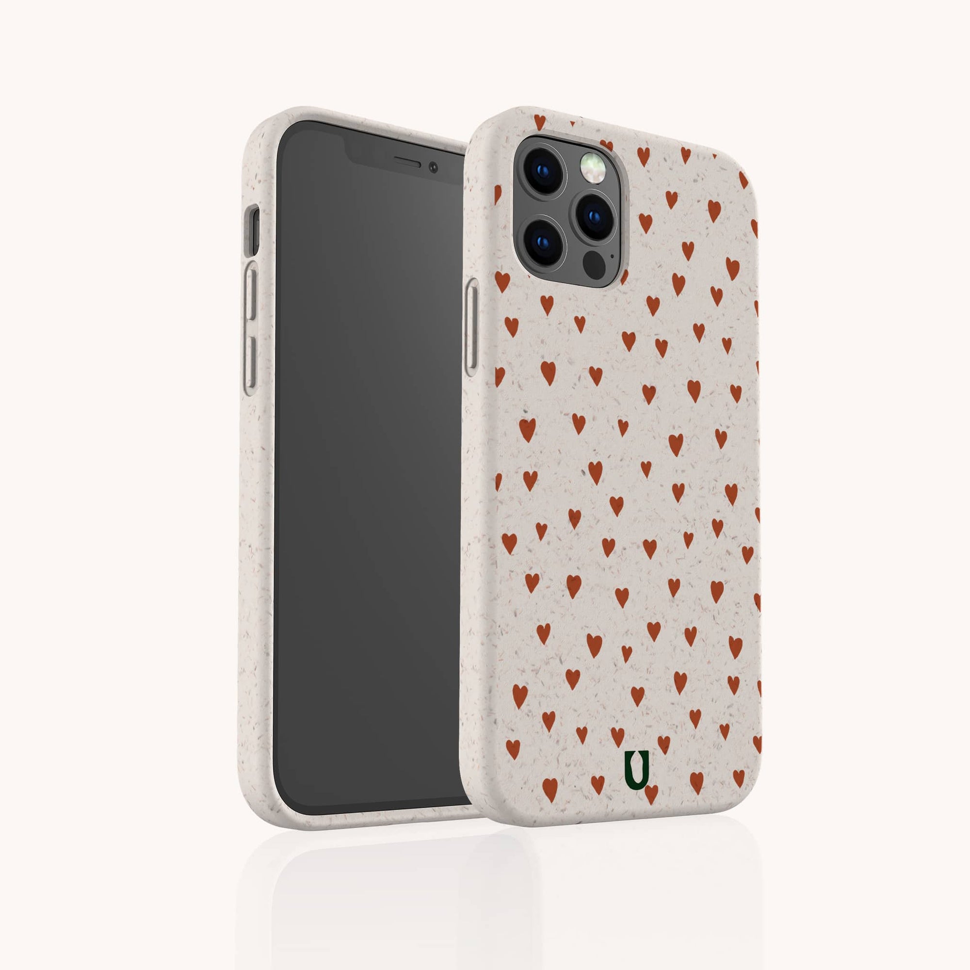 The Red Hearts Eco-Friendly Phone Case in beige, decorated with small red hearts, is shown from front and back to display the heart design and camera cutout. Compatible with iPhone and Samsung Galaxy models.