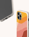 Two Cliffs Eco-Friendly Phone Cases in beige are shown: one displays the screen and ports of a smartphone, while the other reveals the back with a vibrant pink, orange, and yellow abstract wave pattern. These cases are compatible with iPhone and Samsung Galaxy models, providing stylish protection and supporting sustainability.