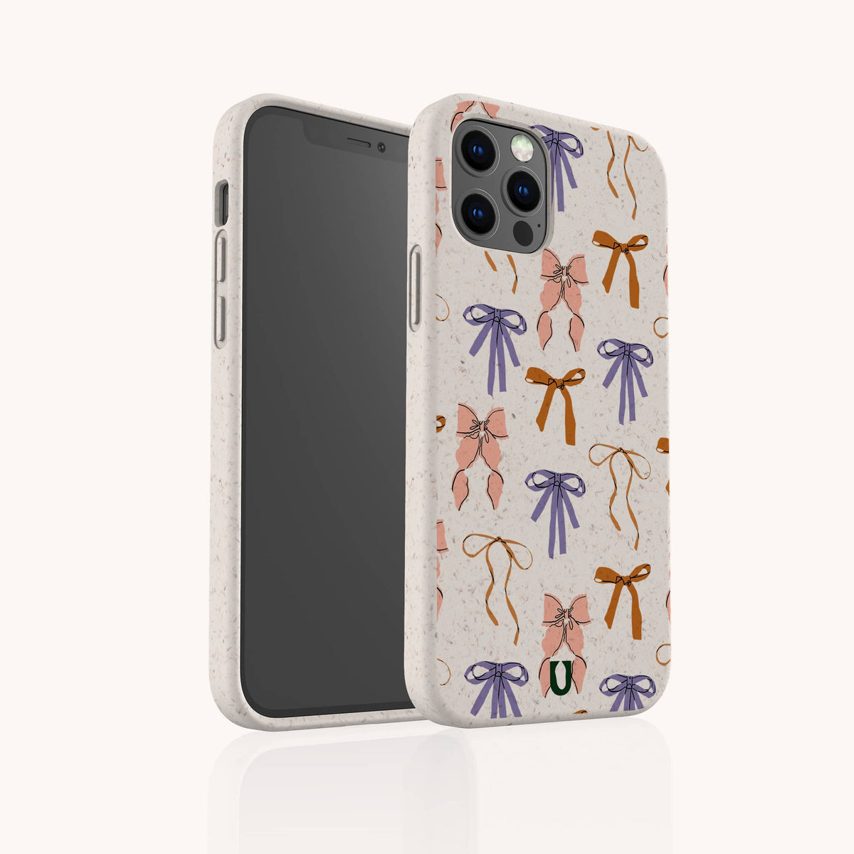 A smartphone stands upright, protected by the Bows Eco-Friendly Biodegradable Phone Case—a light-colored, speckled case adorned with playful illustrations of pink, orange, and purple bows.