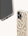 Two smartphones are displayed with the Neutral Swirl Lines Eco-Friendly Phone Case in beige, speckled designs—one showcasing a wavy white line pattern on the back, and the other shown from the front. These minimalist cases provide a stylish, understated appearance while prioritizing eco-friendly materials. The image highlights options compatible with both iPhone and Samsung Galaxy models against a simple light background.