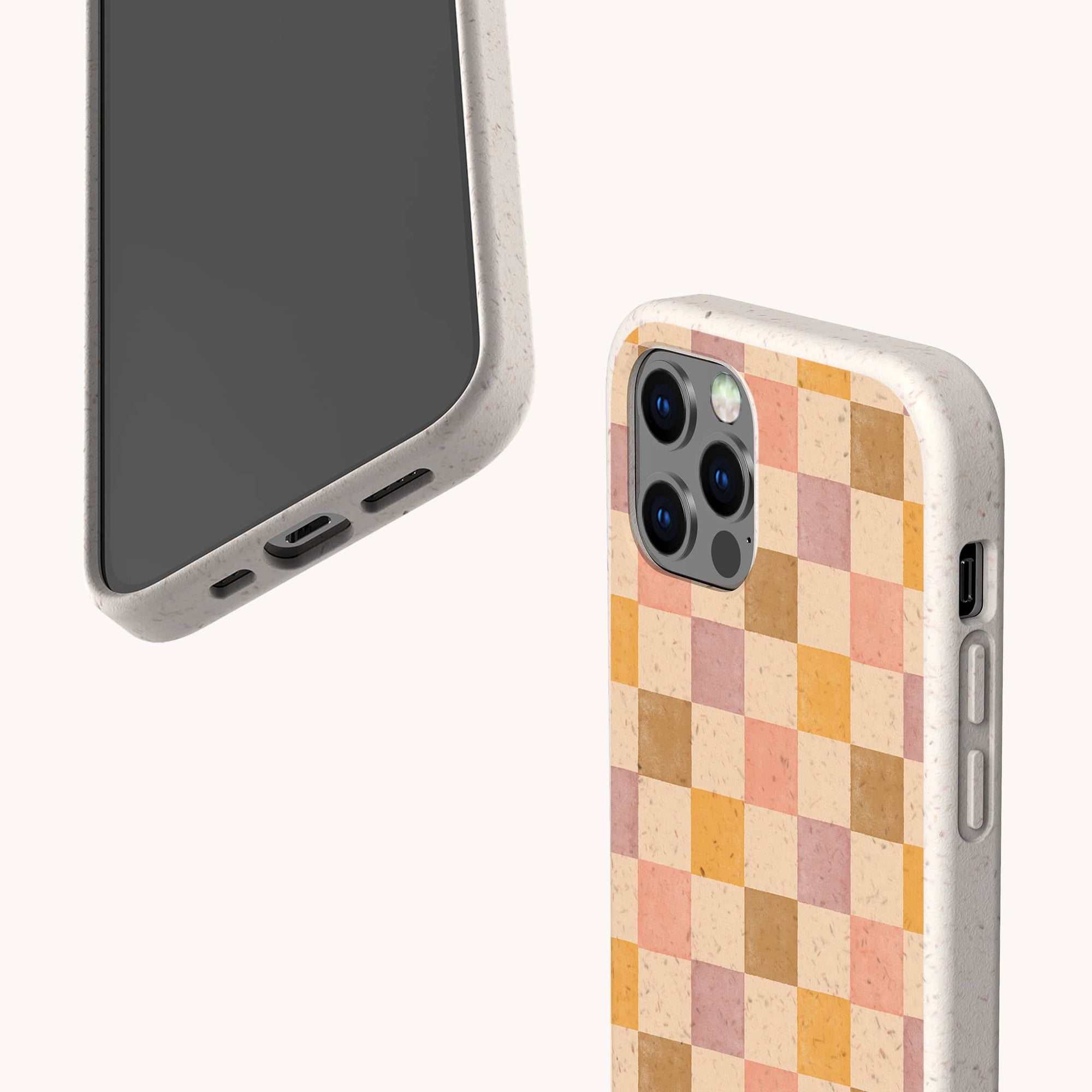 Two smartphones with beige, biodegradable cases: one shows the front, the other displays the back with a pink and purple checkerboard pattern. The Pink and Purple Checker Eco-Friendly Phone Case has cutouts for ports, buttons, and cameras.