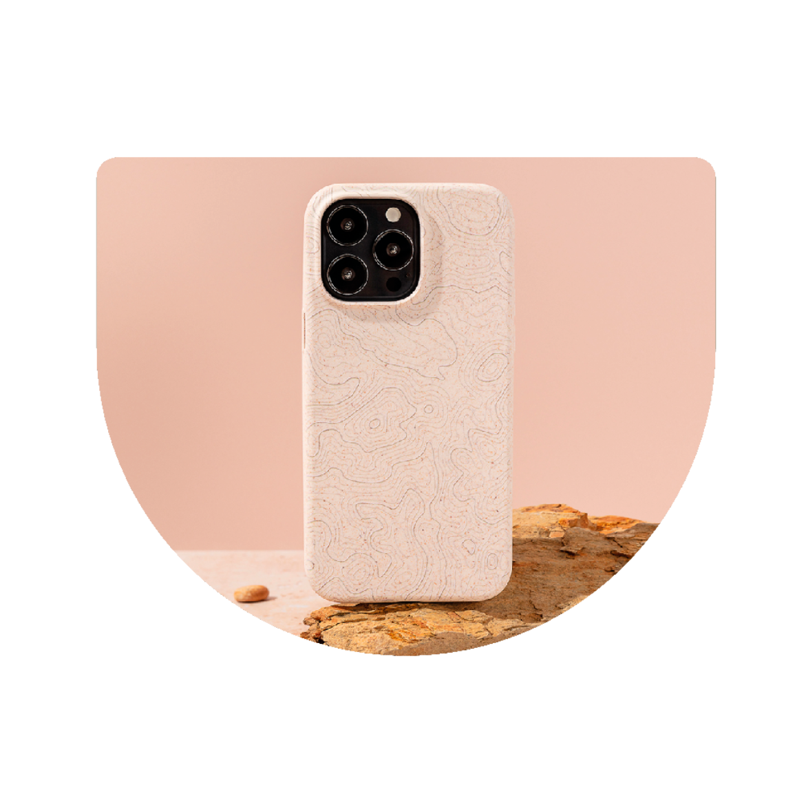 Eco-friendly phone case on a natural wood surface with a soft pink background