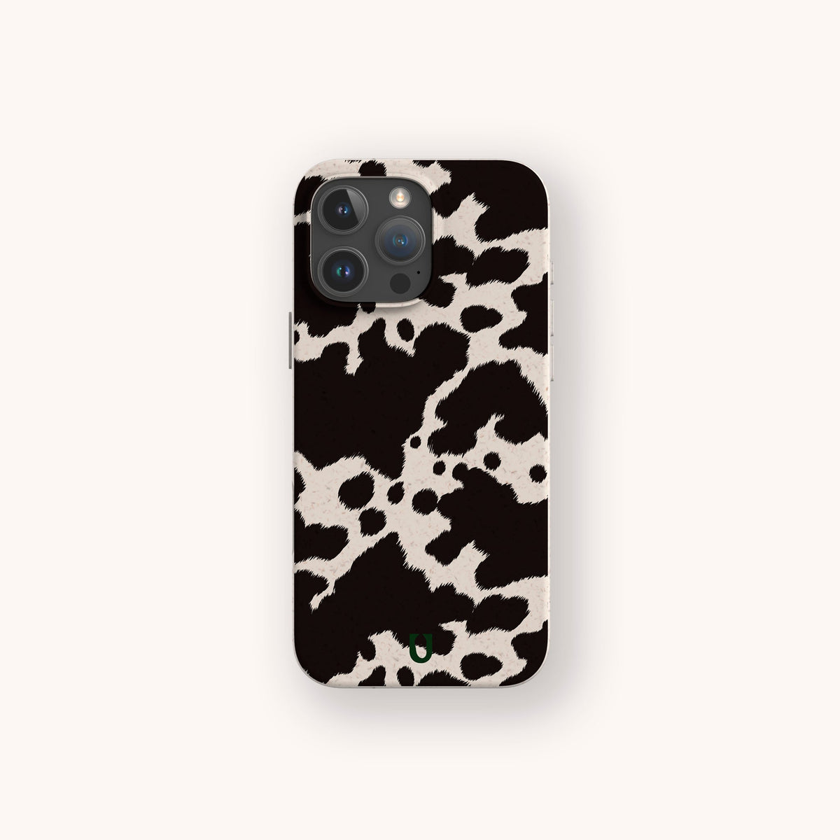 A Cow Print Eco-Friendly Phone Case is displayed on a smartphone against a plain, light background, showcasing its black and white design. The case offers compatibility with both iPhone and Samsung models, emphasizing its stylish and sustainable features.