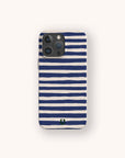 A smartphone with a Navy Stripes Eco-Friendly Biodegradable Phone Case, featuring navy blue and white horizontal stripes and a small green horseshoe-shaped logo at the bottom center.