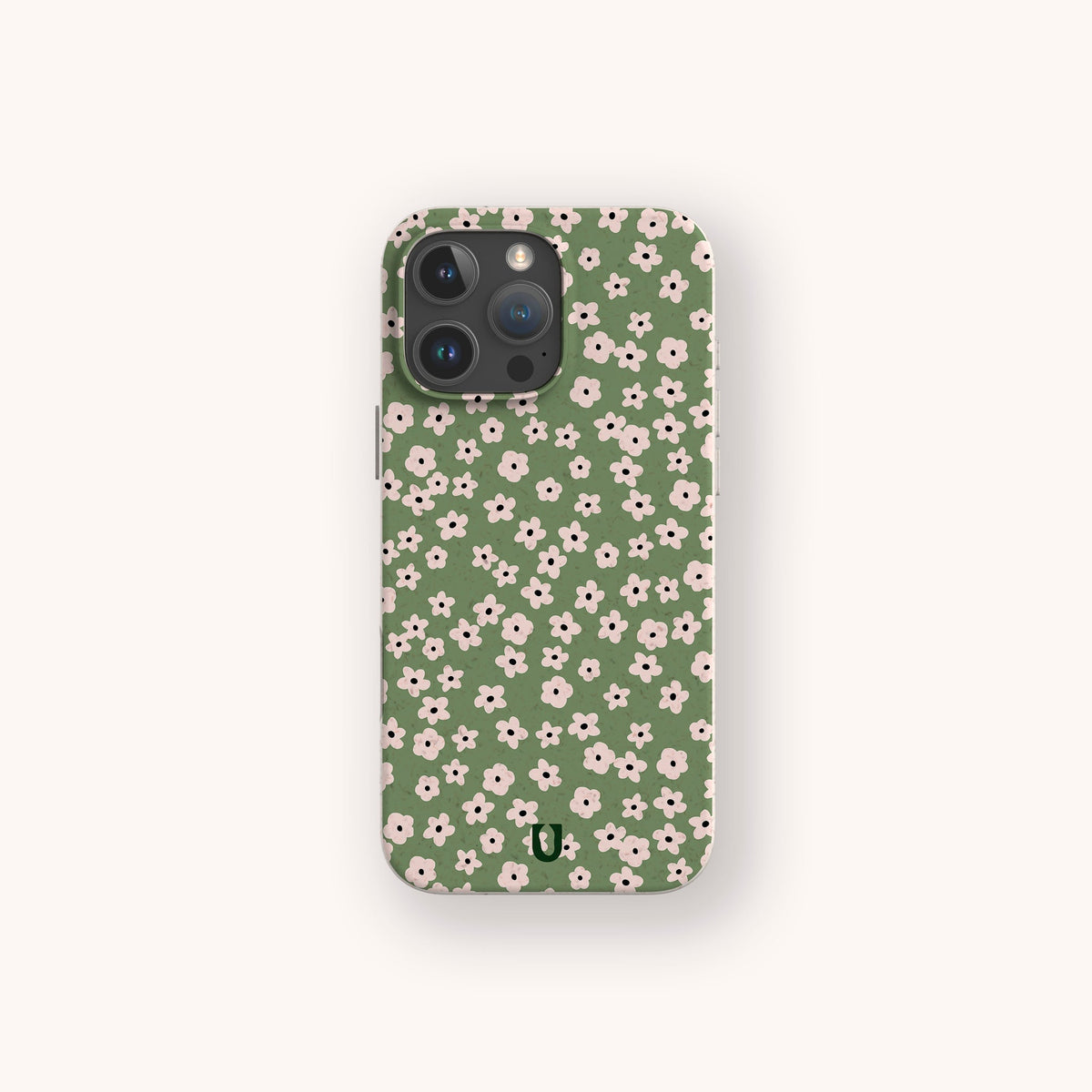 The Vintage Green Flowers Eco-Friendly Phone Case, featuring a green background adorned with a vintage pattern of small white and pink flowers, is displayed against a light beige backdrop.