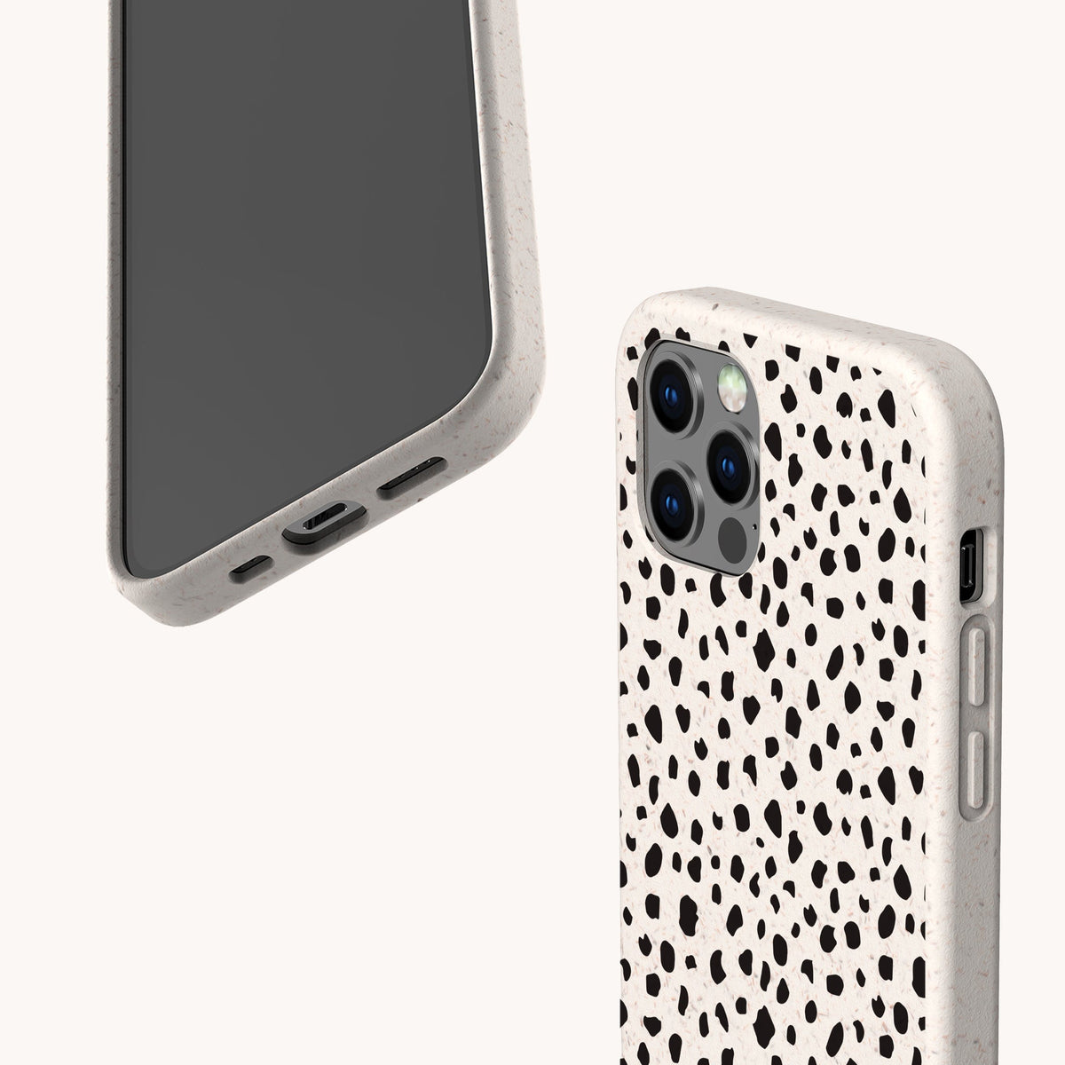 Two smartphones are displayed, one showing the front and one the back. The Dark Spots Eco-Friendly Phone Cases, compatible with both iPhone and Samsung Galaxy models, feature a minimalist white background adorned with black speckles reminiscent of a dalmatian pattern. The cases showcase a triple camera cutout and clearly visible side buttons.