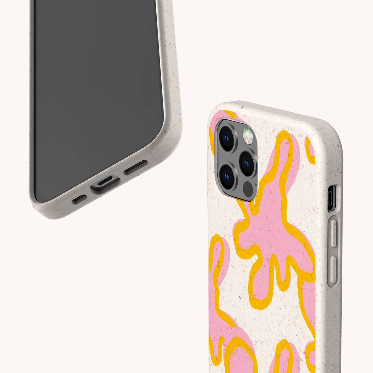 Two smartphones in Pink Abstract Flowers Eco-Friendly Phone Cases. The beige cases feature yellow and pink abstract splashes, creating a playful look inspired by floral designs. Phones are angled to display the case pattern and camera, with screens turned away on a plain background.