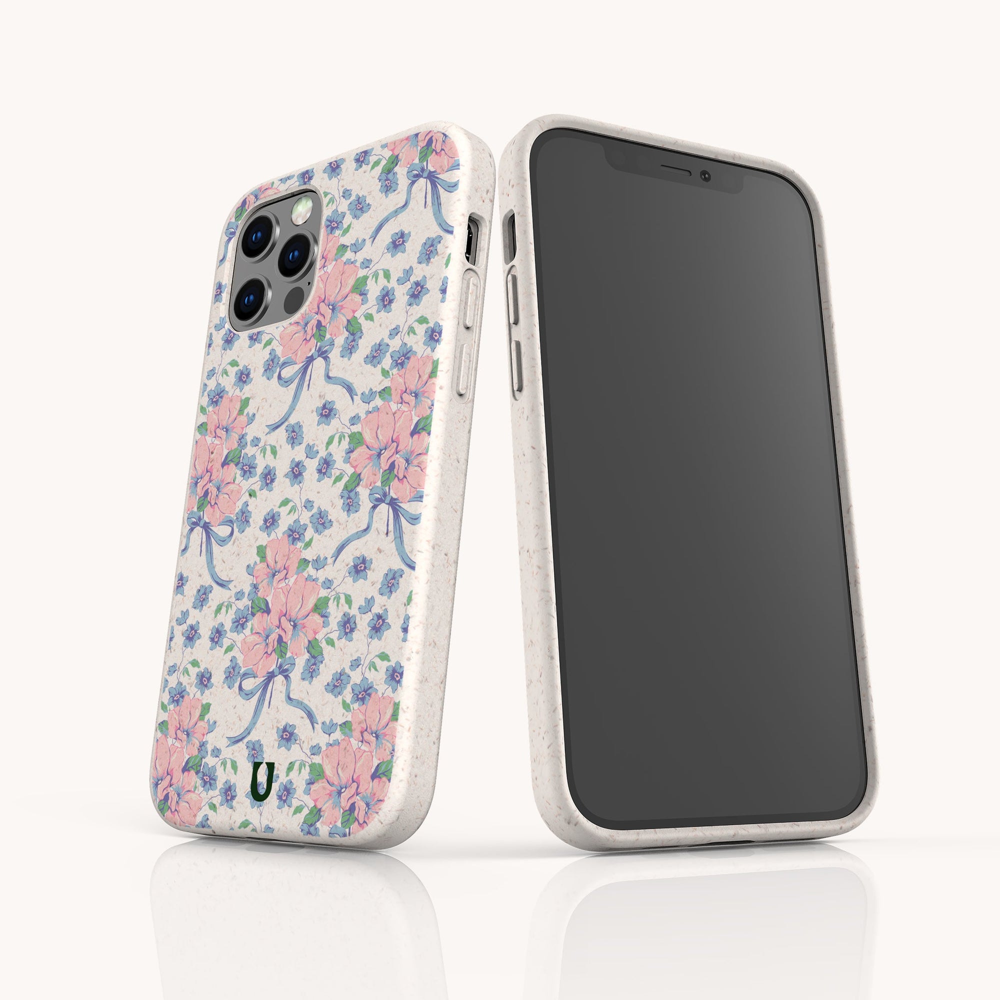 Two smartphones are shown with Pink and Blue Coquette Flowers Eco-Friendly Biodegradable Phone Cases, featuring floral and ribbon patterns on white. One phone faces front; the other highlights the case’s design and camera.