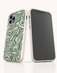Two smartphones in white cases are displayed. One phone stands out with the Green Marble Swirl Eco-Friendly Phone Case, showcasing its abstract wavy green marble design, while the other phone displays its black screen. Both phones rest on a glossy white surface.