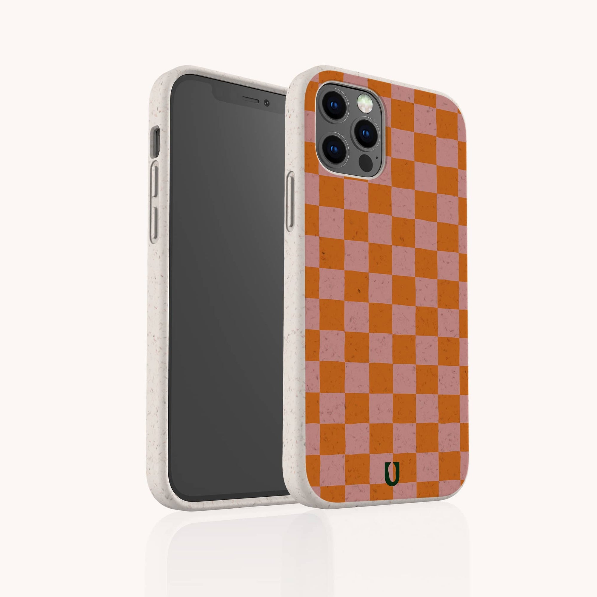 The Orange Checker Eco-Friendly Phone Case features a red and pink checkerboard design, compostable materials, a textured off-white edge, and a small black logo at the bottom center. Shown from front and back angles.