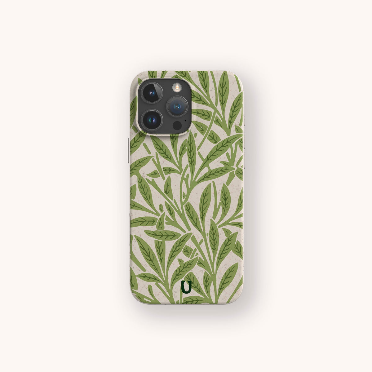 Introducing the Willow Eco-Friendly Phone Case — a plant-based case adorned with a green leafy pattern on a light beige background, shown upright on a simple off-white surface. Perfect for iPhone and Samsung Galaxy users who value both style and sustainability.