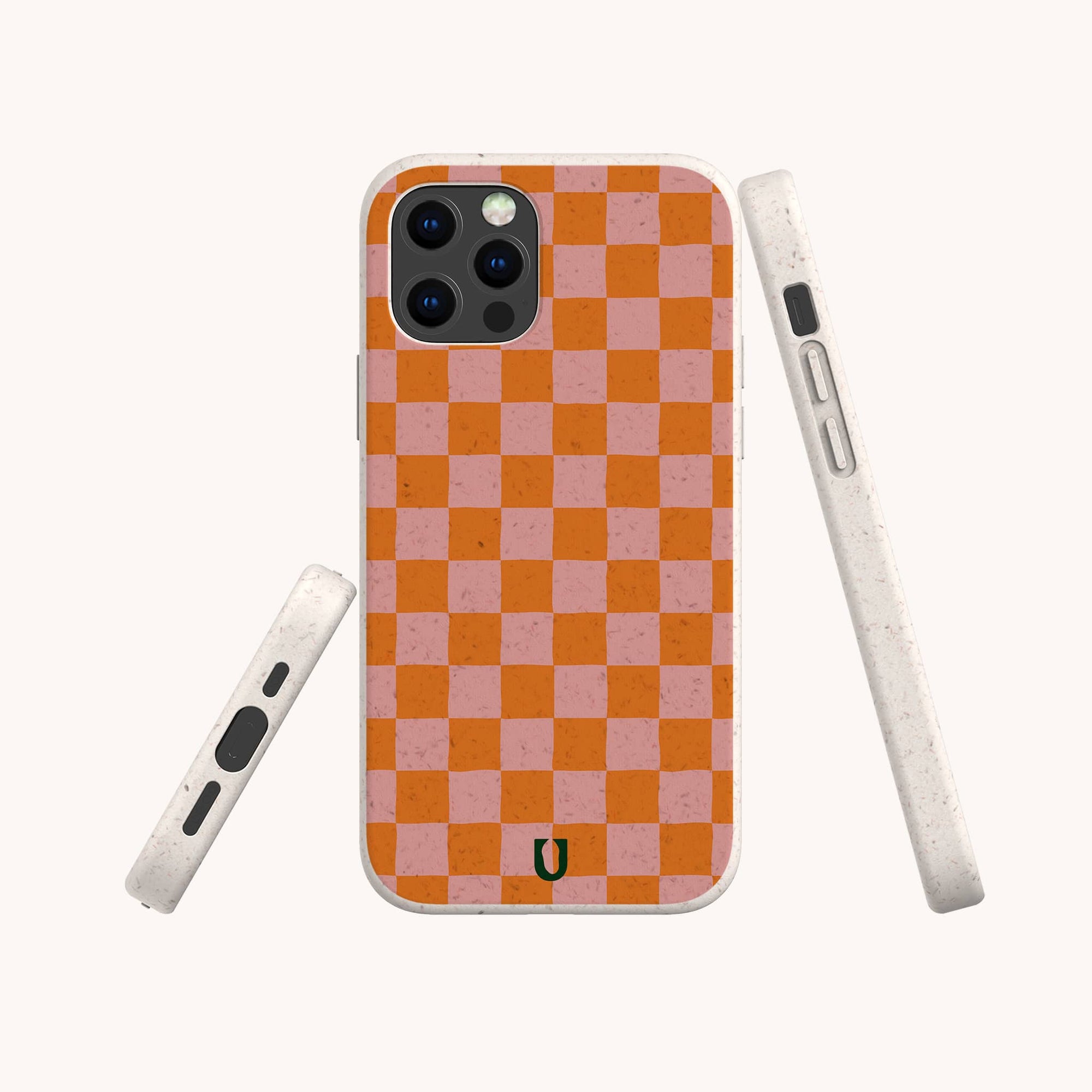 The Orange Checker Eco-Friendly Phone Case, featuring an orange and pink checkerboard design and a small black horseshoe logo at the bottom, is shown from the front, side, and back.