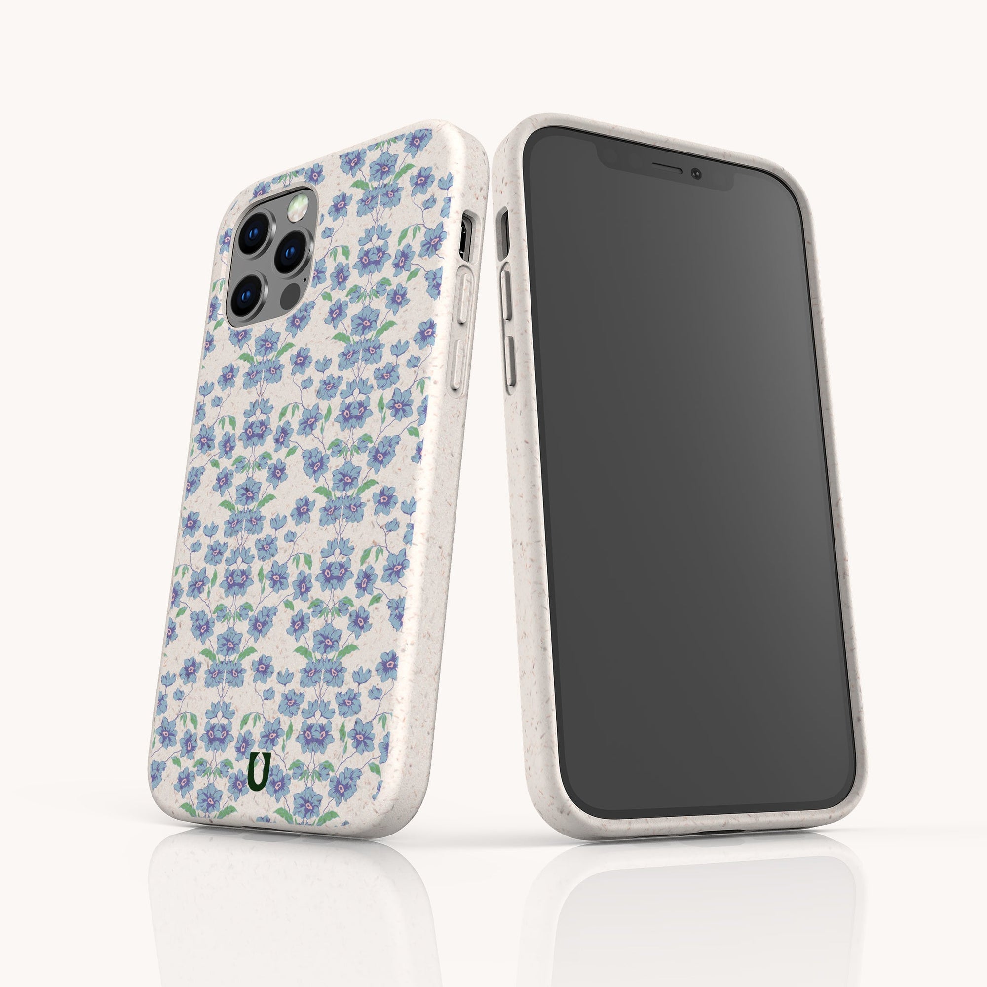 Two smartphones with white cases are shown; one features the Blue Ditsy Flowers Eco-Friendly Biodegradable Phone Case, while the other displays its screen. Both cases have a smooth finish and rounded edges.