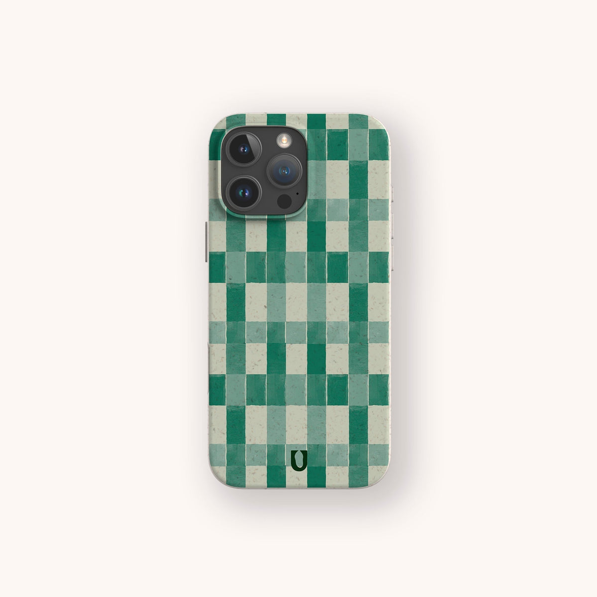 The Green Watercolour Checker Eco-Friendly Phone Case features a green and white checkerboard design, is biodegradable, fits both iPhone and Samsung Galaxy models, and includes a small black horseshoe-shaped logo near the bottom center.